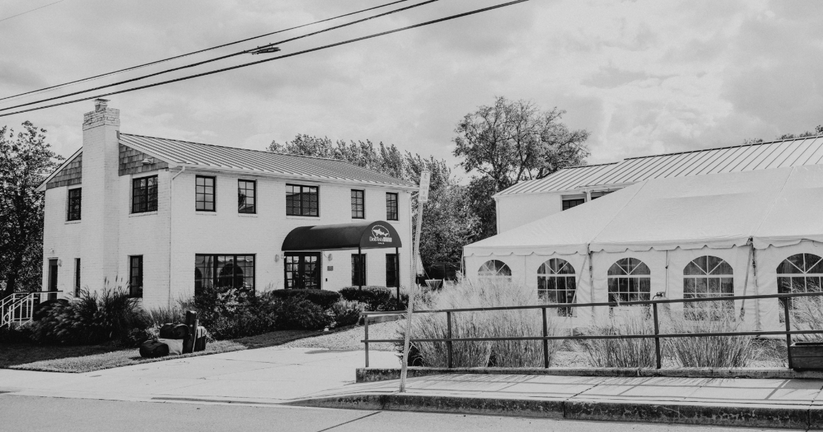 a black and white photo of the dogfish inn with a tent in the parking lot