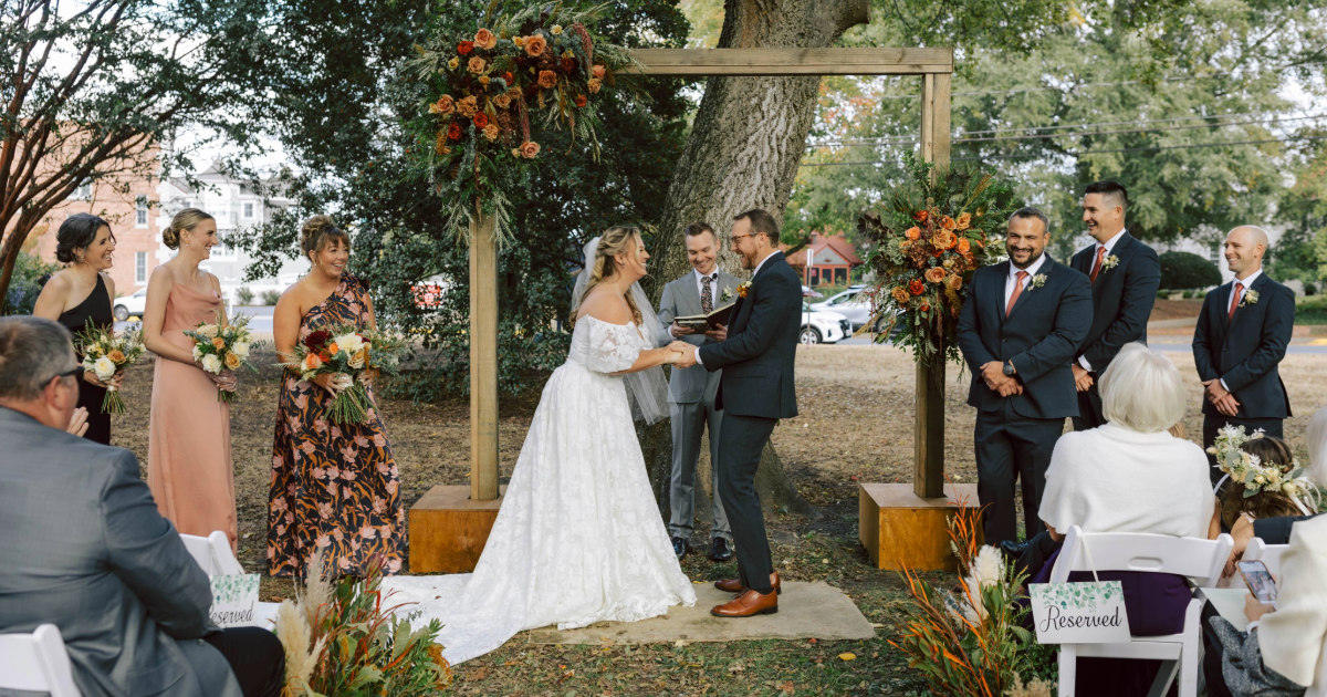 a bride and groom outside under a wedding arbor