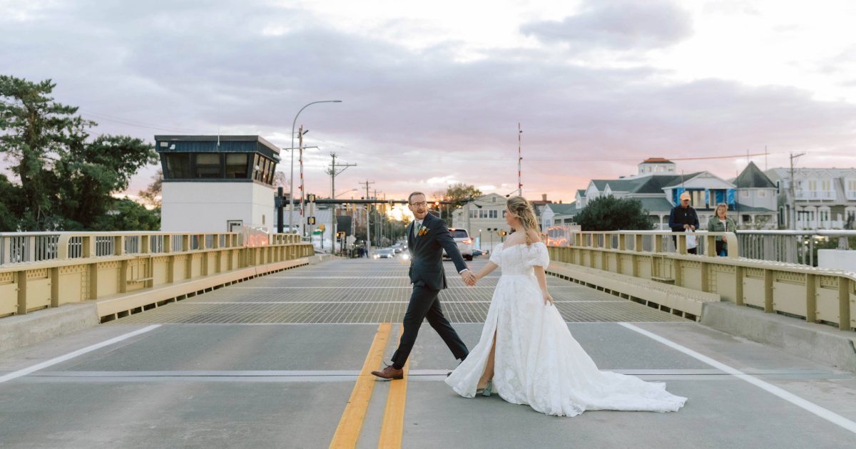 bride and groom on a bridge at sunset