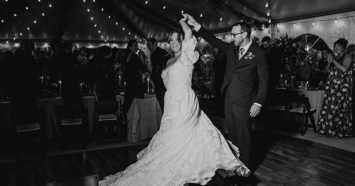 a groom twirling a bride in a black and white photo