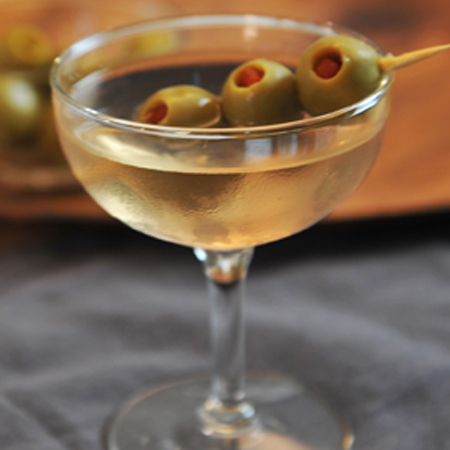 Dirty Vodka Martini in a martini glass garnished with olives