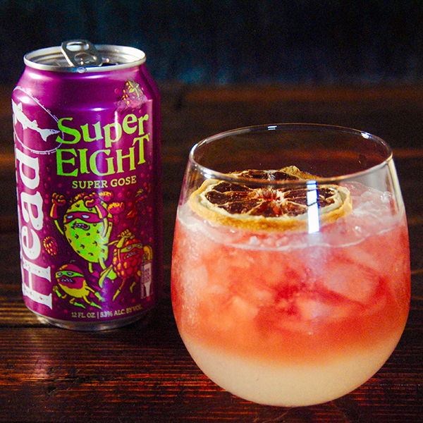 SuperBramble beer cocktail in a glass on a table with a can of SuperEIGHT gose on the side