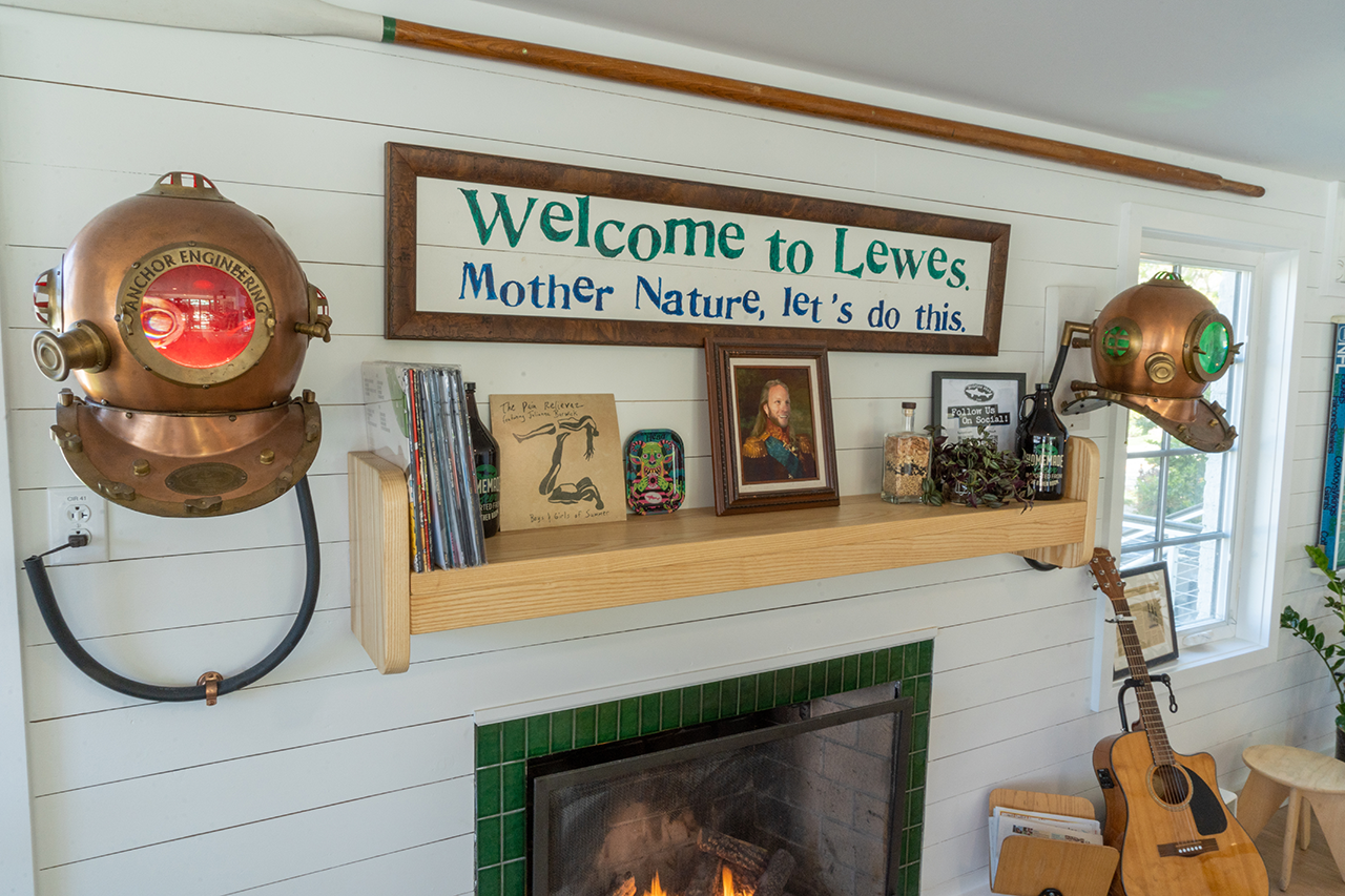 The fireplace mantle at the Dogfish Inn flanked on either side by diving helmets and a place of importance for a portrait of former Innkeeper Andrew