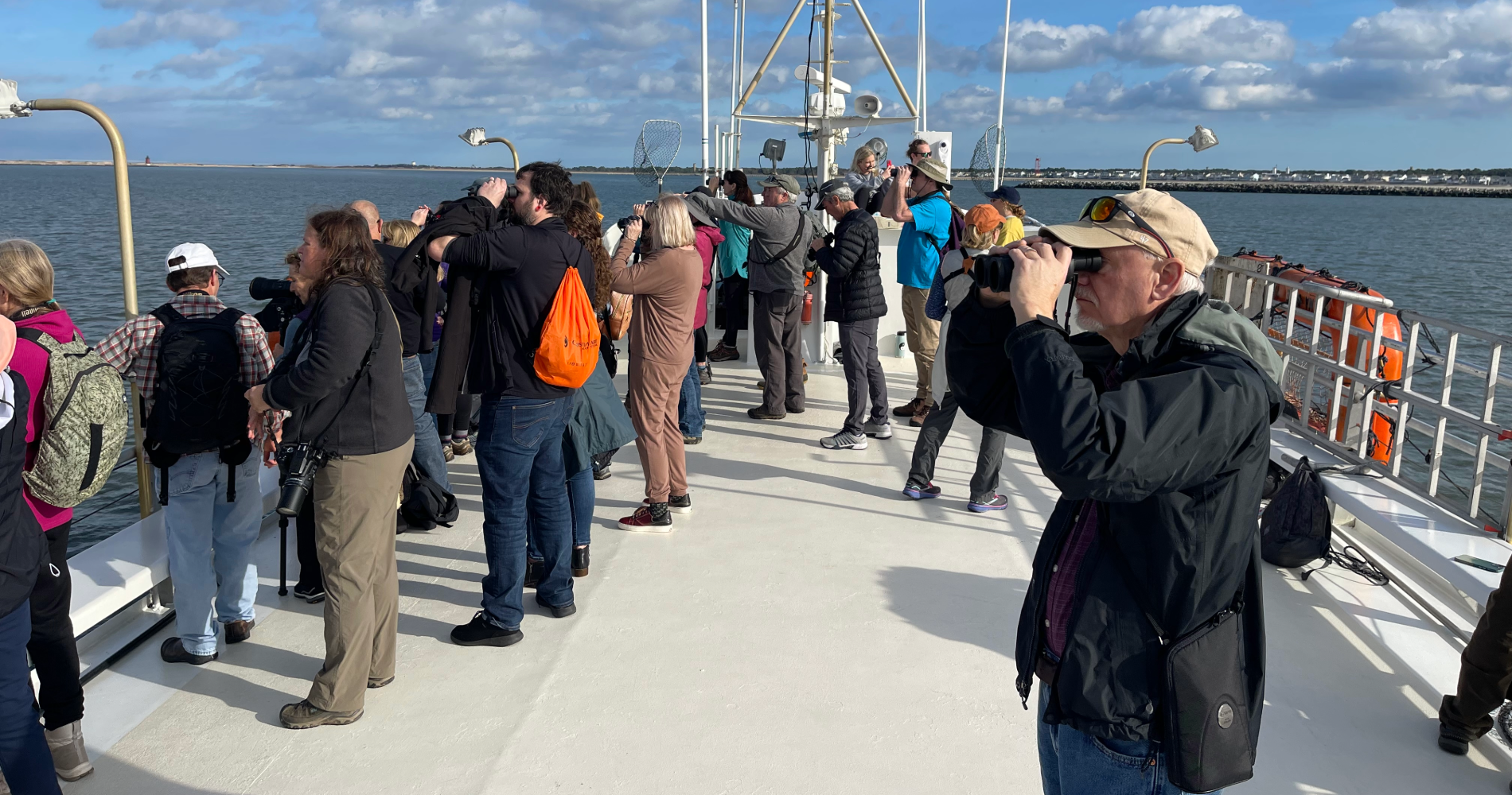 a group of people birding on a large boat