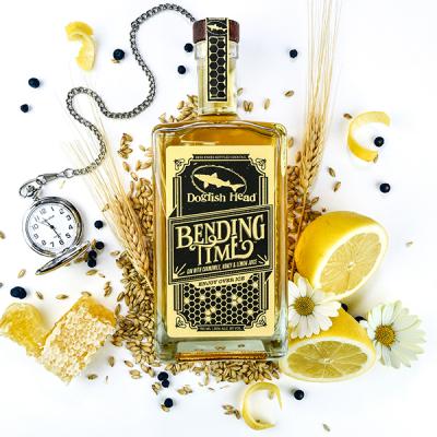A bottle of Bending Time surrounded by cut lemons and other ingredients
