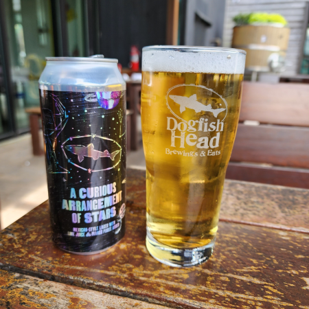 Dogfish Head beer A Curious Arrangement of Stars in a pint glass next to the can