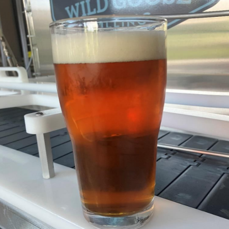 Beer in pint glass sitting on brewery.