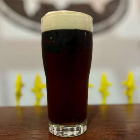 Dogfish Head beer Kept In Suspense that is dark brown with flecks of mahogany in a pint glass