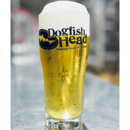 Dogfish Head beer Imperial Pilsener that is brilliant gold with a white head in a pint glass