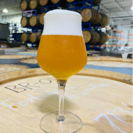 beer in glass on a barrel 