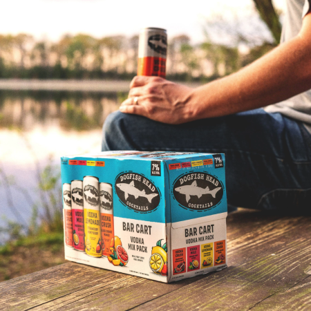 Bar Cart Variety Pack of canned, ready-to-drink cocktail on a dock with a body of water behind it 