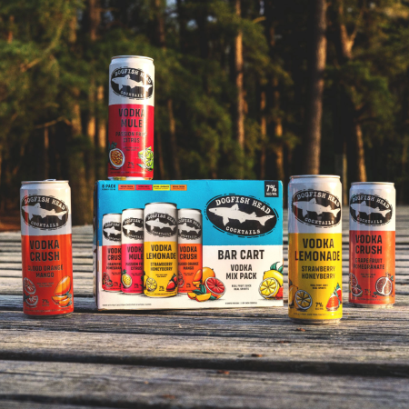 Bar Cart Variety Pack of canned, ready-to-drink cocktail on a dock with a body of water behind it 