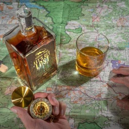 Dogfish Heads Lets Get Lost whiskey on a map table