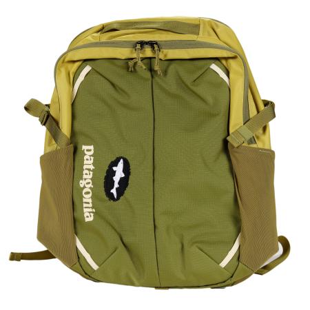 Front view of a two-tone Patagonia backpack in olive green and mustard yellow, featuring mesh side pockets, cream accent lines, a vertical white “patagonia” logo, and a black oval Dogfish Head shark patch on the front panel.