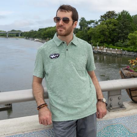 Male model wearing Howler short sleeve textured terry polo with Dogfish Head Since 95 embroidered logo.