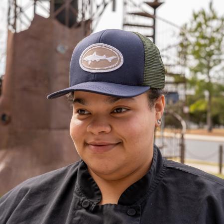 Person wearing Navy and Olive Trucker Hat.