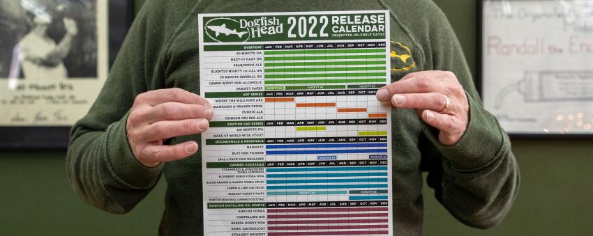 Person holding a printed copy of our 2022 beverage calendar.