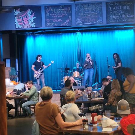 Coworker singing karaoke on stage with band