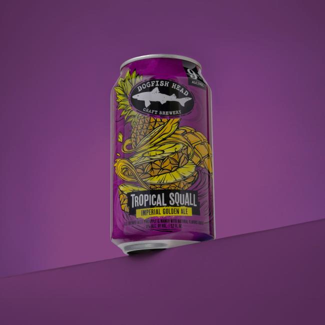 Dogfish Head Tropical Squall can on a purple ledge with a purple background