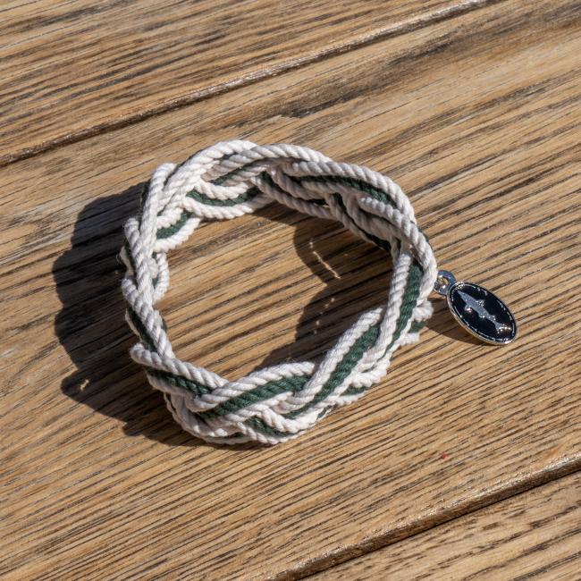 Dogfish Head Rope Bracelet with charm. Photographed on a wood surface. 