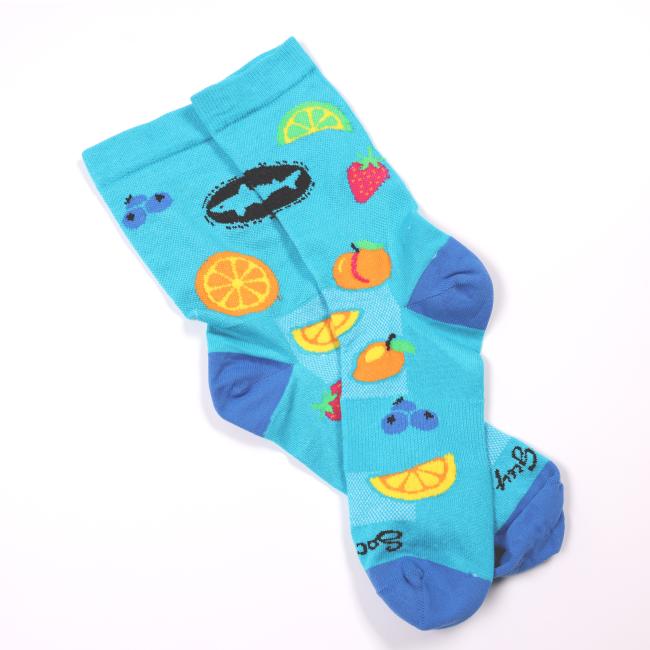 Pair of bright blue Dogfish Head socks with colorful fruit designs including orange slices, lemon wedges, strawberries, mangoes, and blueberries, with darker blue heels and toes.