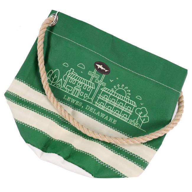 Overhead angled view of the green Dogfish Head bucket bag laid flat, showing the illustrated design and coiled rope handle.