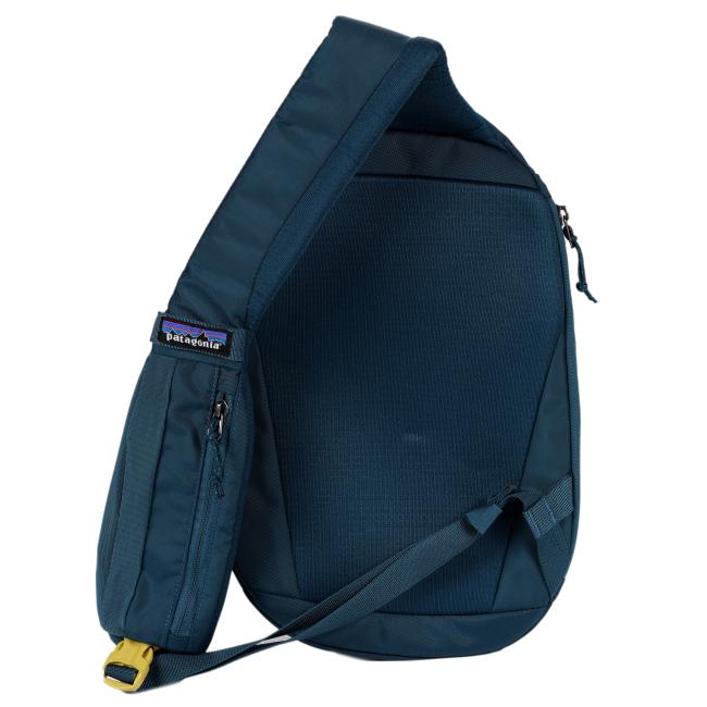 Back view of the sling backpack showing the padded shoulder strap, textured back panel, and a Patagonia woven label tag near the zipper pocket.