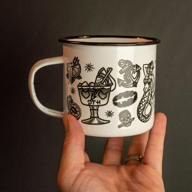white enamel mug featuring black all over tattoo art 