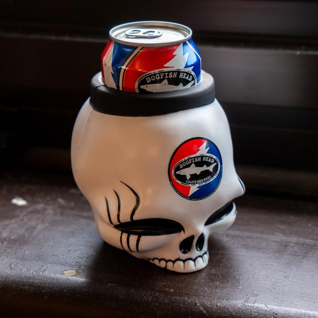 A white skull-shaped can cooler with the Dogfish Head x Grateful Dead design on it.