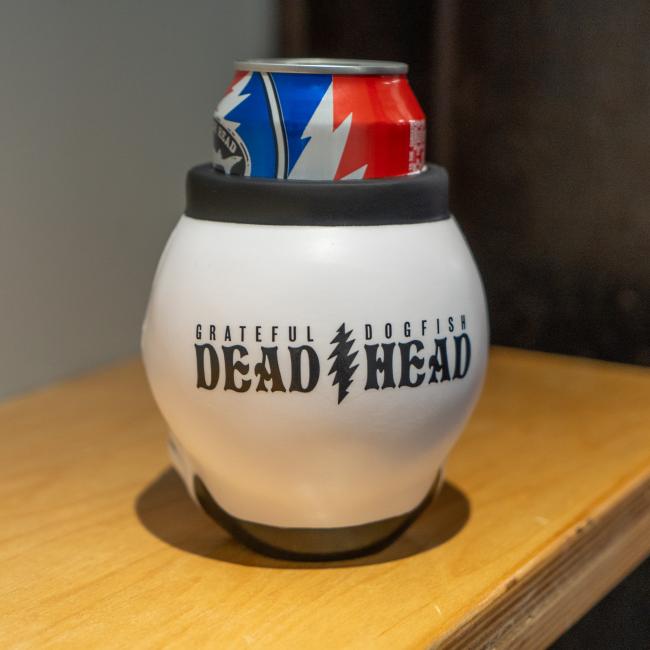A white skull-shaped can cooler with the Dogfish Head x Grateful Dead design on it.