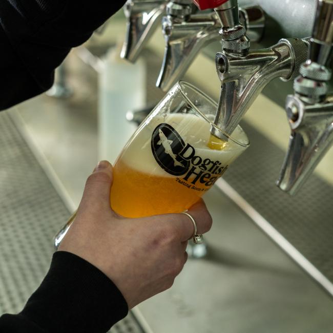 Person pouring beer into glass.