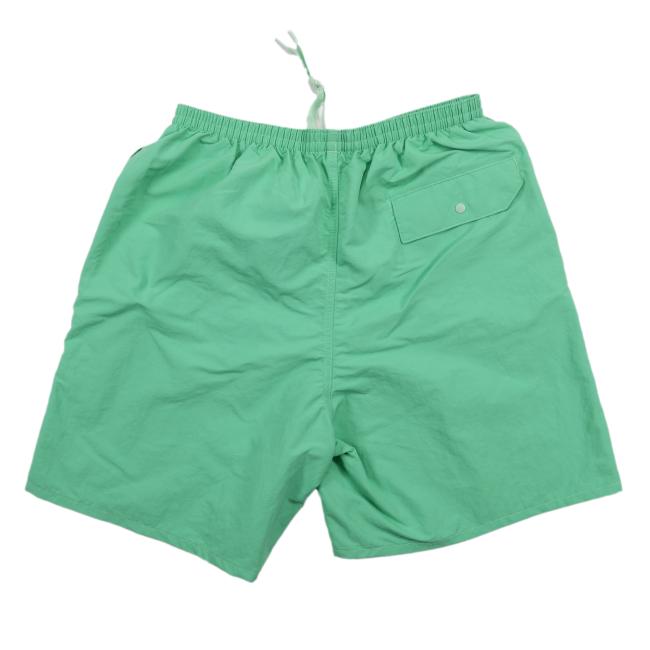 Back view of the light green Patagonia shorts showing an elastic waistband and a single flap pocket with a button on the right side.