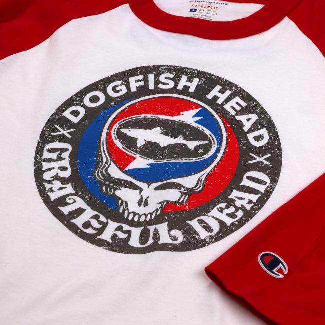Close up of the white base baseball tee with red sleeves and trim with the Dogfish Head x Grateful Dead logo on the front.