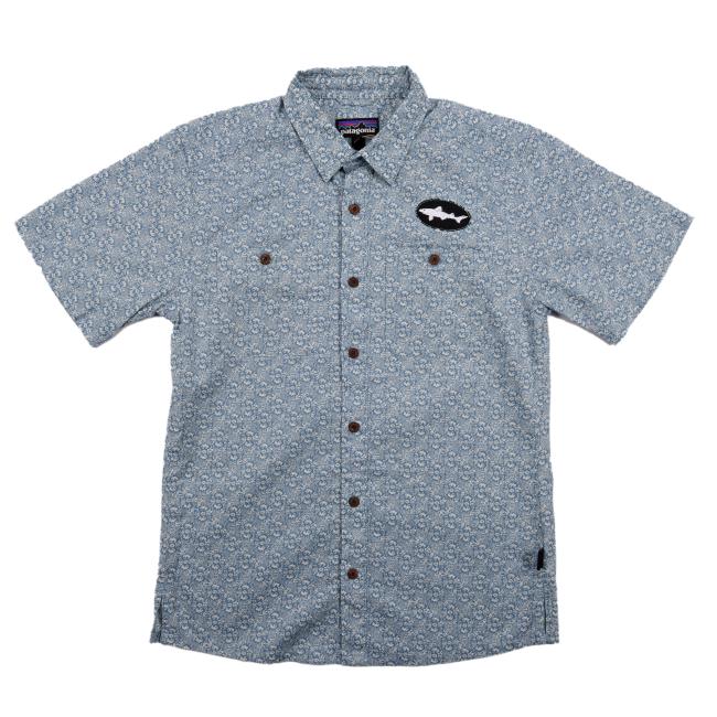 Front view of the patterned Patagonia button-up shirt featuring brown buttons, dual chest pockets, and a black oval Dogfish Head shark patch on the left chest.