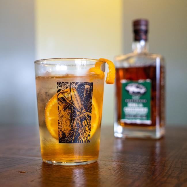 A glass with the Dogfish Head x Boathouse design in black.