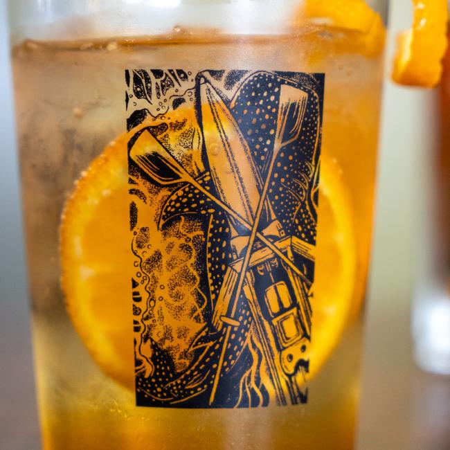 A glass with the Dogfish Head x Boathouse design in black.