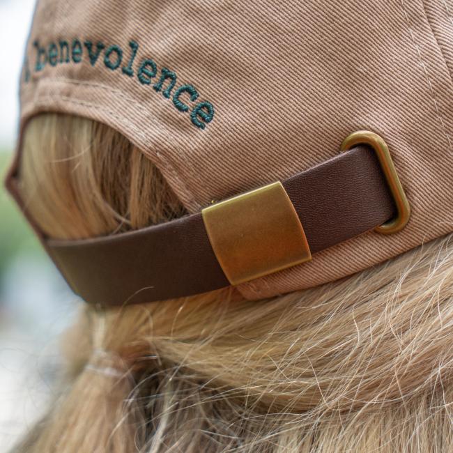Close-up of the brown leather adjustable strap with brass hardware on the back of the hat.