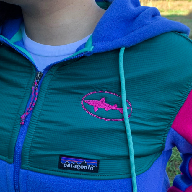Dogfish Head and Patagonia Women's Blue and Green Microdini Hoody With Pink Sleeves and Dogfish Head Shark Logo In Pink On Front Close Up View