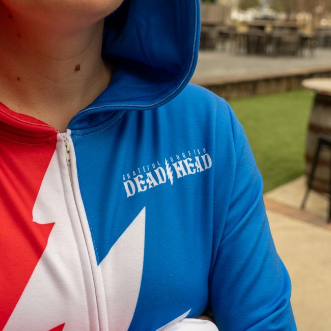 Adult unisex hooded zip front onesie. Red and blue with white grateful dead lightening bolt. Small Dogfish Head text. 