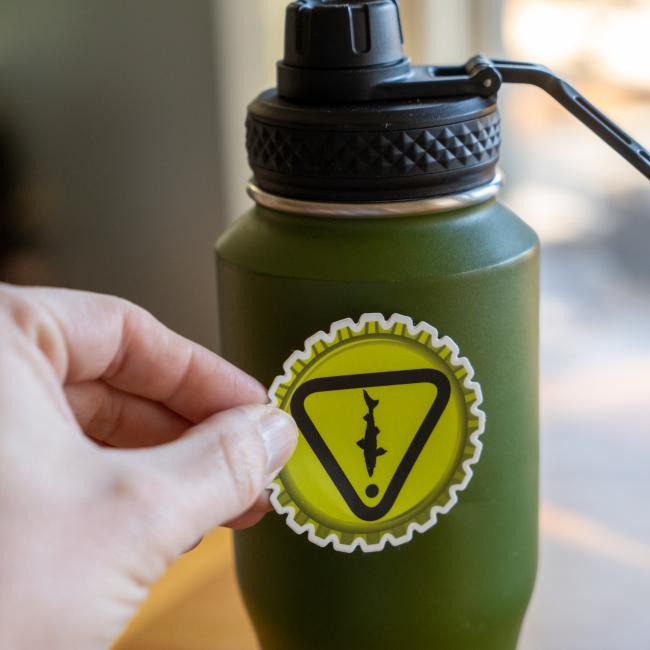 Dogfish Head Caution Sticker In Bright Yellow On A Green Thermos