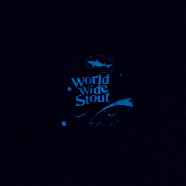 Dogfish Head World Wide Stout Tee Up Close of Glowing Galaxy and Dogfish Head Logo In The Dark