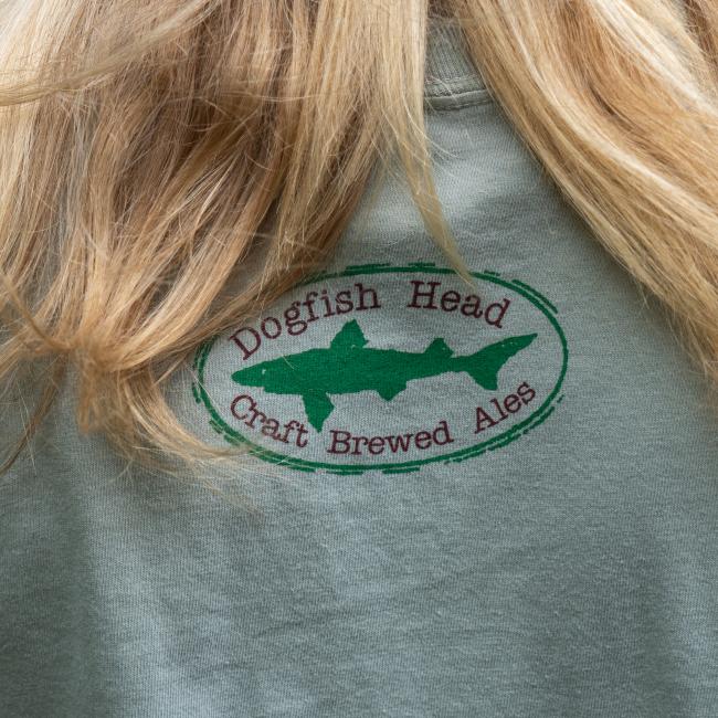 Close-up view of the back of the t-shirt, featuring the classic Dogfish Head logo in green with