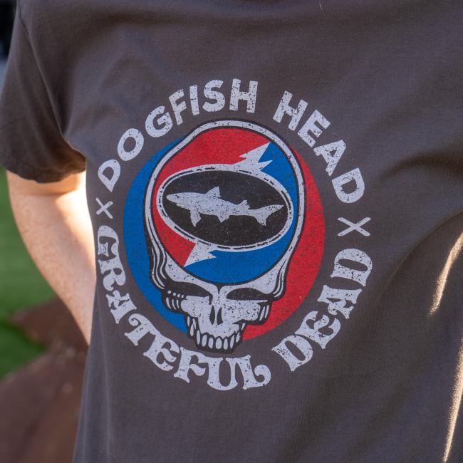 A charcoal colored tee shirt with the Dogfish Head and Grateful Dead collaboration logo on the front.