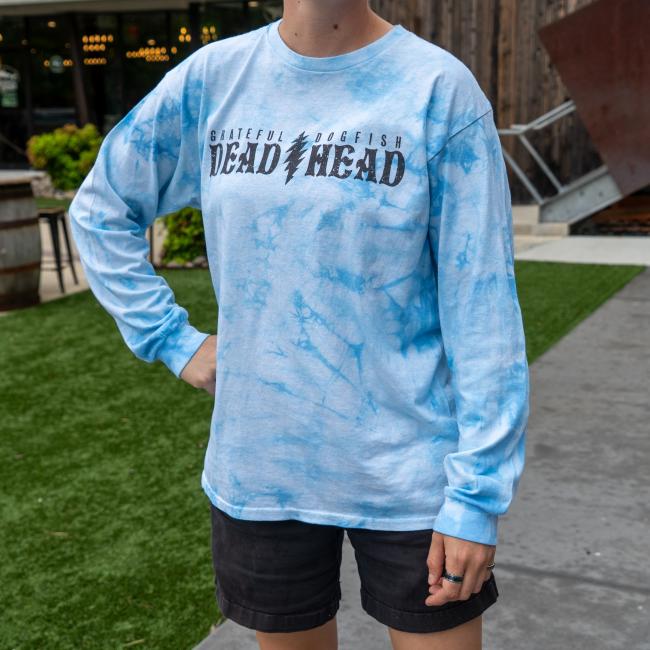 Front of a blue tie-dye long sleeve shirt showing the phrase “GRATEFUL DOGFISH DEAD HEAD” across the chest in bold distressed lettering.