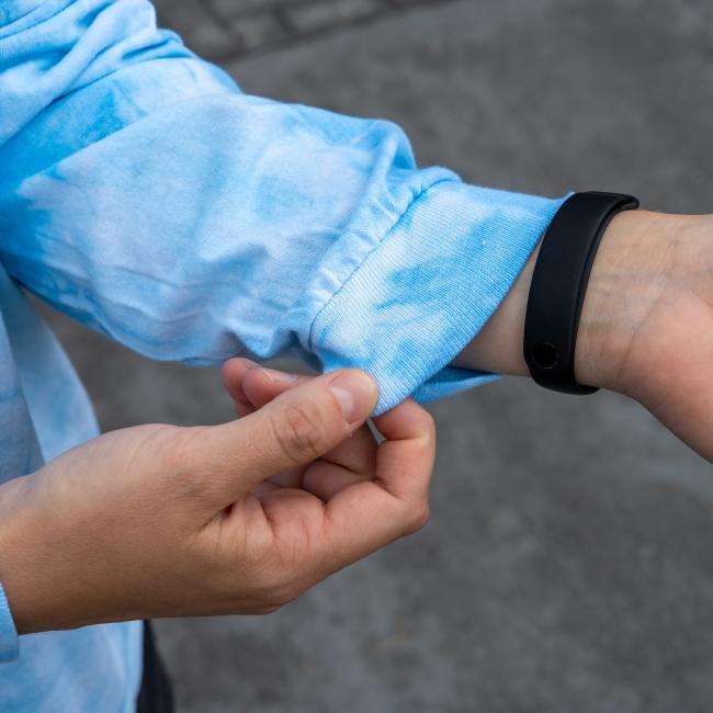 Close-up of the shirt’s sleeve cuff being gently tugged, showing the soft cotton fabric and ribbed wrist detail.