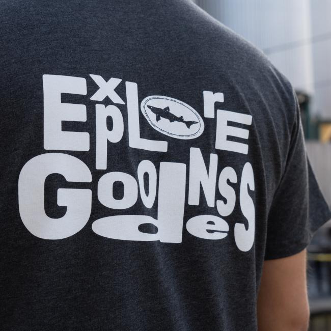 Charcoal Explore Goodness Tee in Dark Grey with Explore Goodness in White Lettering Close Up View of Back